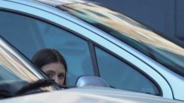 Genç kadın gizlice araba arkasında saklanıyor fotoğraf çekmek, tabloid foto muhabirliği