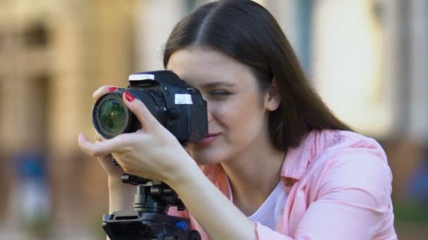 Pretty smiling female photographer calibrating camera lens mass media profession — Stock Video