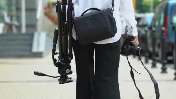 Fotógrafa que lleva cámara y trípode con estuche, equipo profesional — Vídeo de stock