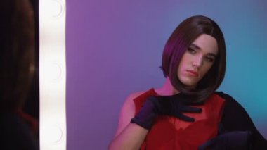 Kadın elbiseleri üzerinde çalışan peruk giyen transseksüel, travesti gösterisi, çapraz giyinme