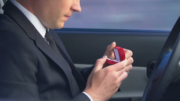 Insecure man holding wedding ring sitting in car, overcoming engagement anxiety — Stock Video