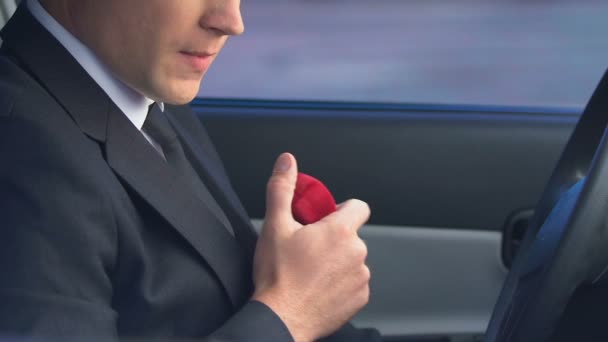 Man holding wedding ring hesitating to marry, scared of family responsibilities — Stock Video