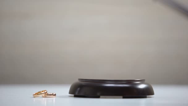 Anéis de casamento na mesa, martelo marcante no bloco de som, processo de divórcio, tribunal — Vídeo de Stock
