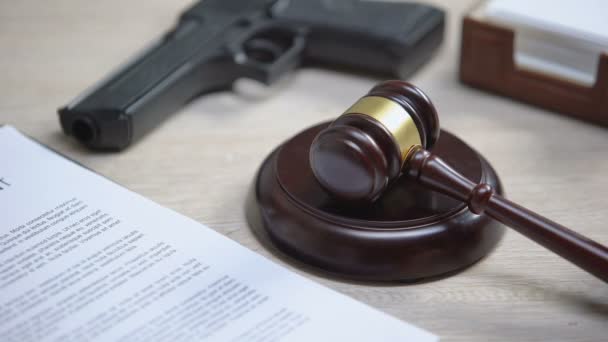 Pistolet na stole, młotek uderzające na bloku dźwięku, nielegalne użycie broni, rozprawy sądowej — Wideo stockowe