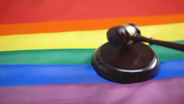 Gavel opvallend op geluid blok, regenboog vlag op tafel, homogemeenschap legalisatie — Stockvideo