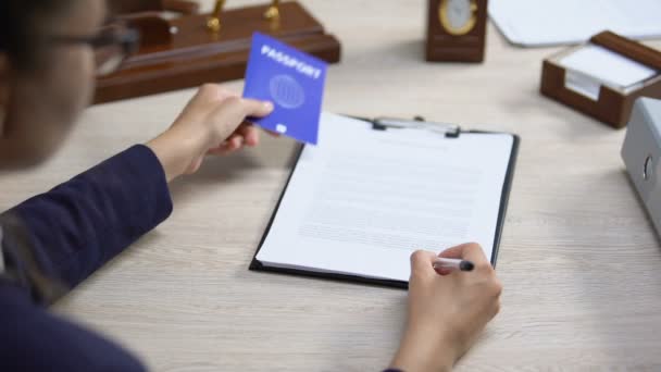 Empleado firma documento de deportación con pasaporte azul, derecho internacional — Vídeo de stock