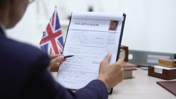 Especialista de la embajada niega solicitud de visa sentada oficina, mesa bandera británica — Vídeos de Stock