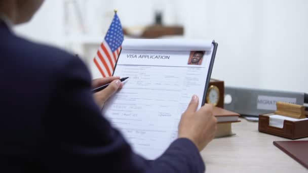 Female immigration inspector denying visa application, american flag on table — Stock Video