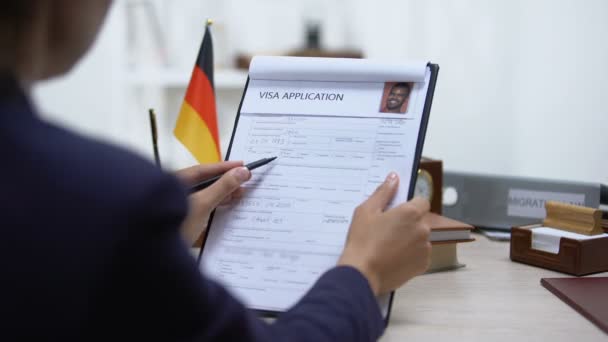 Inspector de inmigración niega solicitud de visa, bandera alemana en la mesa, embajada — Vídeos de Stock