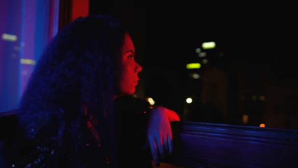 Znudzony modny kobieta siedzi samotnie w pobliżu okna, nieciekawy w prywatnej imprezie — Wideo stockowe