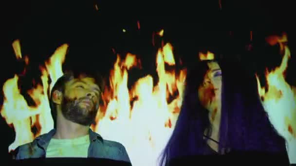 Man and woman swallowing ecstasy pills against fire background, getting high — Wideo stockowe