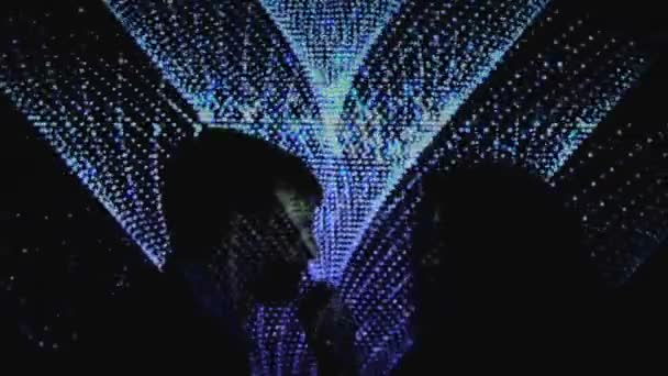 Man och kvinna ömt kysser mot nattklubb belysning bakgrund — Stockvideo