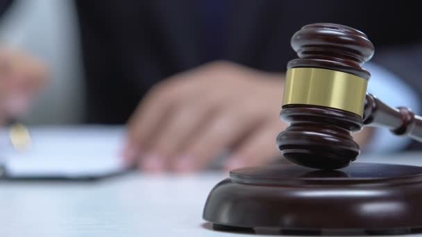 Mahkeme belgesi ile çalışan erkek avukat, masada toklak, adalet kavramı — Stok video