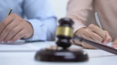 Erkek ve kadın prenuptial anlaşma imzalayan, masada nişan yüzükleri ile tokluk