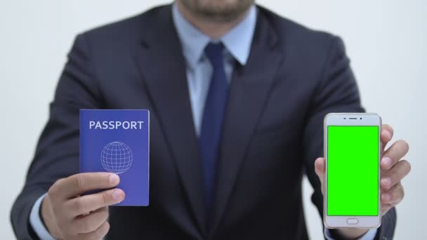 Manager con pasaporte y smartphone con pantalla verde, registro en línea — Vídeos de Stock