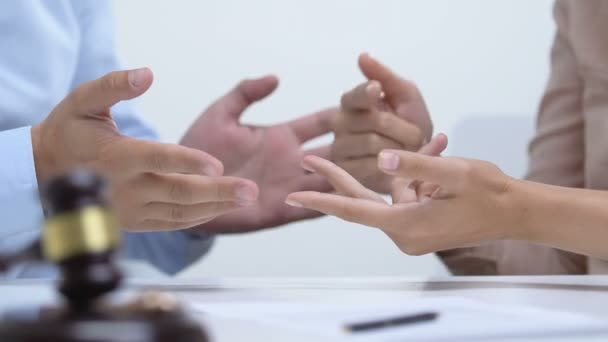 Pareja discutiendo en la corte, mazo con anillos de compromiso en la mesa, concepto de divorcio — Vídeos de Stock