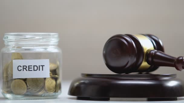 Credit jar with coins, judge striking gavel, debt collection, payment problems — Stock Video