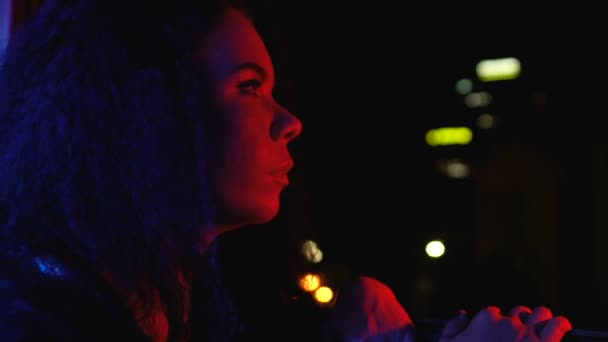 Genç kadın alacakaranlık şehir ayakta balkon, gece yaşam tarzı, yalnızlık görünümlü — Stok video