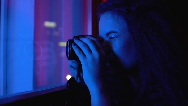 Fotógrafo feminino sorridente tirando fotos de celebração através de vidro de janela — Vídeo de Stock