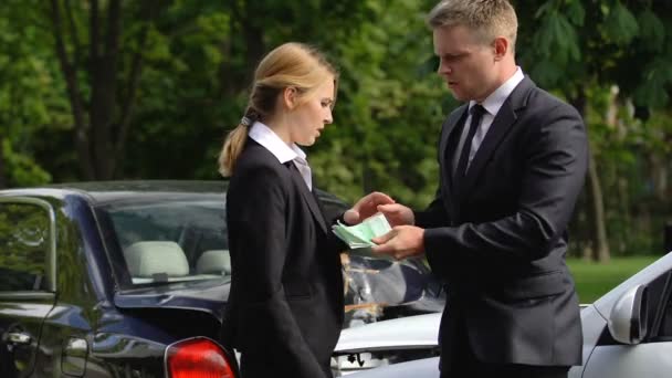 Mannelijke chauffeur geeft eurobankbiljetten jonge vrouw, verkeers botsing, reparatie betaling — Stockvideo