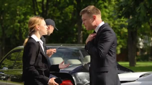 Pilotes de voiture stressés criant les uns les autres devant le policier près de voitures écrasées — Video