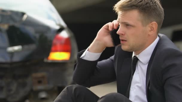 Беспокойный человек разговаривает по телефону на открытом воздухе сломанный автомобильный фон, ДТП — стоковое видео
