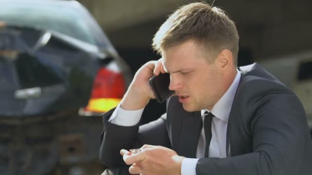 Gestrest mannetje nemen pil gevoel nerveus na auto-ongeluk, praten over de telefoon — Stockvideo