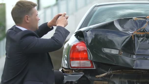 Mužský ovladač fotografovat poškozené auto smartphone, pojištění pro vozidla — Stock video