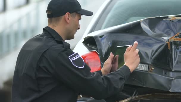 写真を撮る警官は、タブレットとオンラインレポート、デバイスを埋めることによって自動クラッシュしました — ストック動画