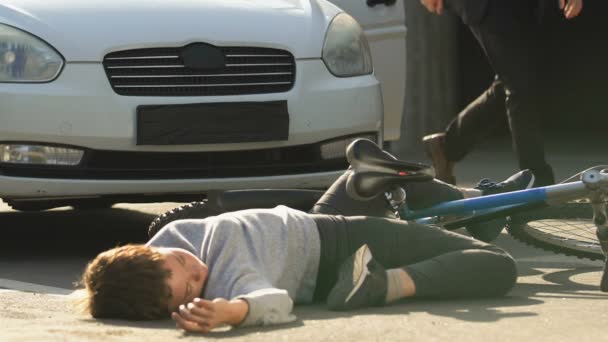 Assustado masculino motorista olhando para bateu inconsciente adolescente deitado rua perto de bicicleta — Vídeo de Stock