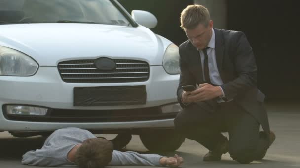 Nervous car driver calling ambulance, unconscious pedestrian hit by car street — Stock Video