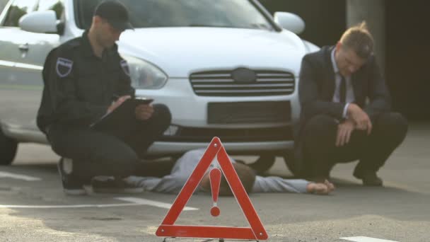 Señal de peligro vial frente a policía y conductor de coche culpable en la escena del accidente automovilístico — Vídeos de Stock