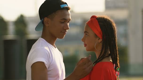 Czarny nastolatków chłopak czule Dotykanie dziewczyny podbródek, moment przed pocałunek, Randki — Wideo stockowe