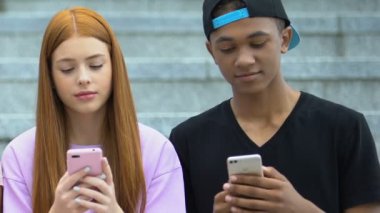 Çift ırklı erkek genç güzel arkadaşına akıllı telefon uygulaması gösteriyor, alet bağımlılığı.