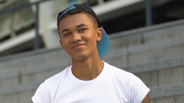 Ragazzo adolescente afro-americano fiducioso che sorride alla macchina fotografica all'aperto, futuro — Video Stock