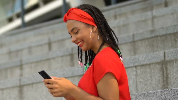 Sonriente afroamericana adolescente chateando con amigos en red social, diversión — Vídeo de stock