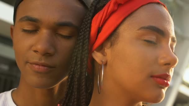 Afroamerikansk tonåring par kramas med slutna ögon, drömmer om framtiden — Stockvideo