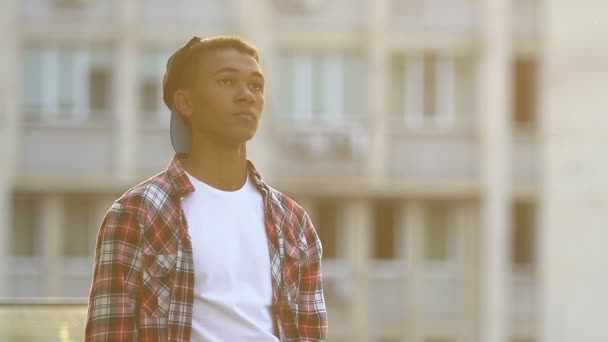 Afro-americano adolescente esperando amigos en la calle de la ciudad, estilo de vida — Vídeo de stock