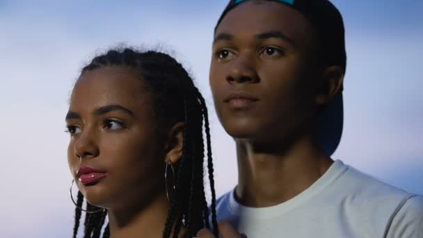 Afro-americano casal adolescente abraçando com os olhos fechados no pôr do sol, sonhando acordado — Vídeo de Stock