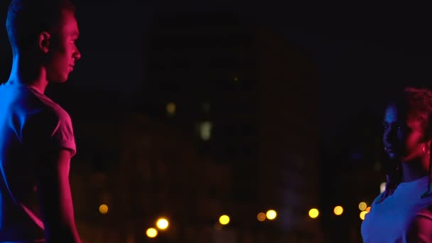 Atraente casal adolescente afro-americano abraçando entre luzes da cidade noite, amor — Vídeo de Stock