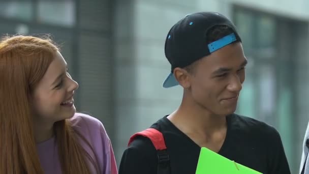 Felices estudiantes multiétnicos masculinos y femeninos con cuadernos hablando y riendo — Vídeo de stock