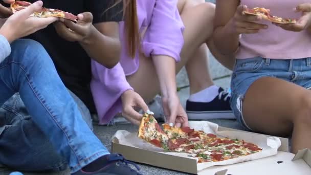 Adolescents affamés prenant des morceaux de pizza appétissants, ayant collation à l'extérieur, fastfood — Video