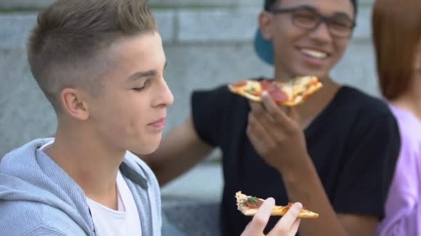 Feliz grupo de amigos disfrutando de una apetitosa pizza al aire libre y riendo, merienda — Vídeos de Stock