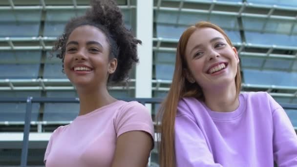Játékos multiracionális női barátok kommunikálnak barátaikkal az akadémia közelében — Stock videók