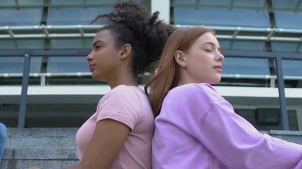 Elegantes millennials fêmeas sentadas nas escadas do campus amigos descansando nas proximidades — Vídeo de Stock