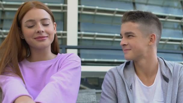 Pelirroja tímida adolescente mirando a su compañero de clase masculino, chico sonriente sintiendo simpatía — Vídeo de stock