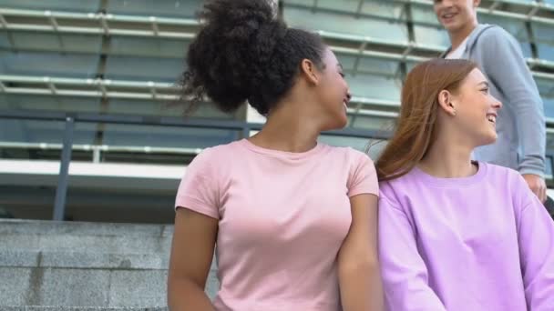 Αυτοπεποίθηση καυκάσιος έφηβος να εξοικειωθούν με τις καλές φίλες, φλερτάρουν — Αρχείο Βίντεο