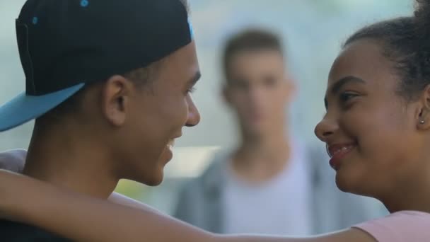 Eifersüchtige männliche Teenager beobachten beste Freundin flirtet mit Freundin, bedrohen Kerl — Stockvideo