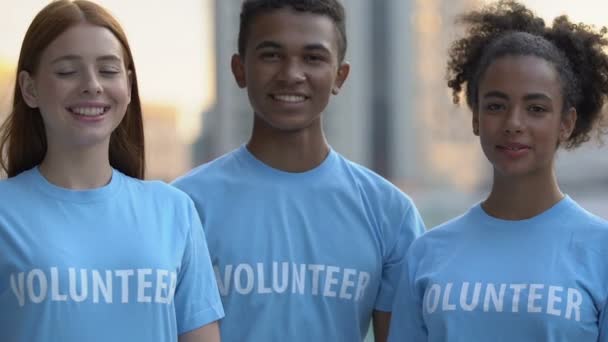 Εξαιρετικά ευτυχισμένοι πολυφυλετικοί εθελοντές φίλοι που δείχνουν αντίχειρες-up κάμερα, φιλανθρωπία — Αρχείο Βίντεο