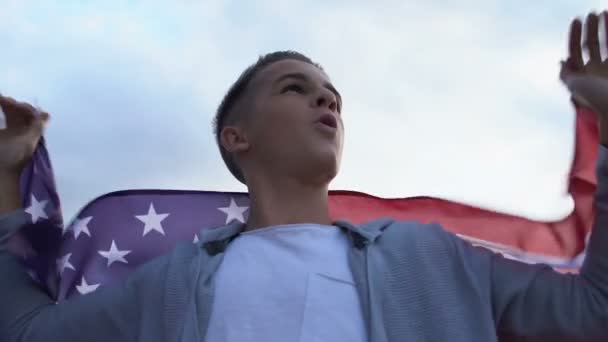 Orgoglioso adolescente maschio sventola bandiera USA, sostenendo il concetto di patriottismo della squadra nazionale — Video Stock
